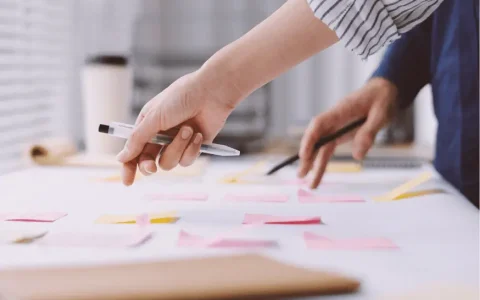 Close-up of business professionals collaborating over a table with sticky notes, planning a structured SMSF setup workflow
