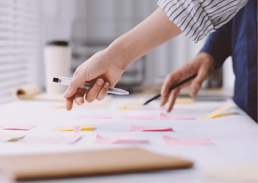 Close-up of business professionals collaborating over a table with sticky notes, planning a structured SMSF setup workflow