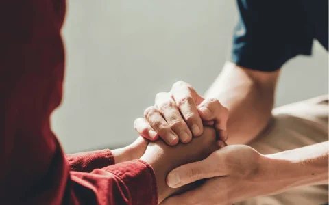 Close-up of two people holding hands, symbolising trust and support in managing financial or legal responsibilities through an Enduring Power of Attorney.