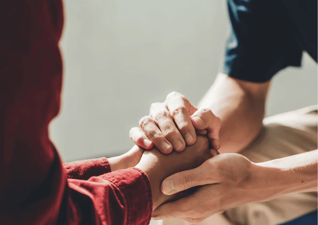 Close-up of two people holding hands, symbolising trust and support in managing financial or legal responsibilities through an Enduring Power of Attorney.