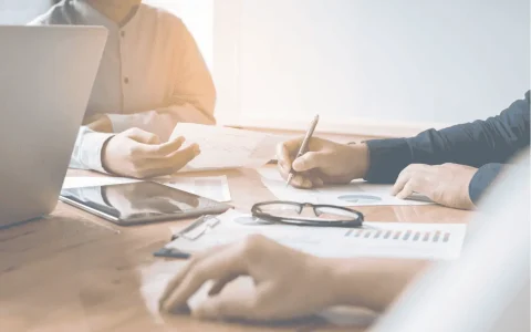 Advisers reviewing SMSF actuarial certificate requirements at a meeting table.